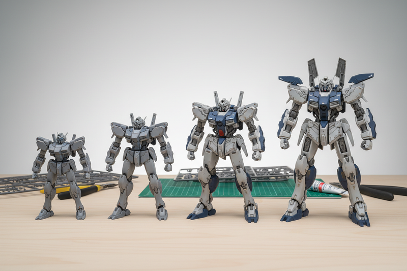 Four unbranded plastic mecha model kits arranged from smallest to largest on a hobby workbench, illustrating the increasing size and detail of Gunpla grades.