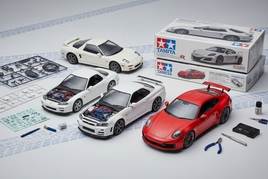 1/24 scale Tamiya model car kits featuring Nissan Skyline GT-R, Porsche 911, Honda NSX, and Mazda RX-7 on clean background
