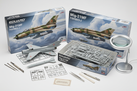 1/48 scale Eduard MiG-21 jet fighter model kits with photo-etched parts and decals displayed on workbench with modeling tools