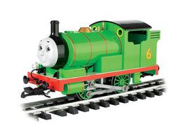 Green toy train engine with the number 6 on the side, smiling face, and red trim on model railroad track