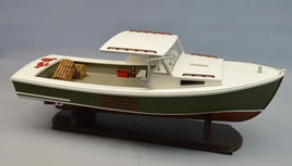 Model of a vintage fishing boat with green hull, white cabin roof, and wooden crates on deck