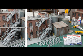 HO scale industrial model kit with brick building, metal stairs, ladders, and hobby tools on workbench