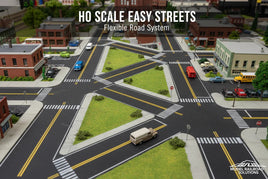 HO scale model street layout with detailed roads, cars, and buildings for model railroad setup