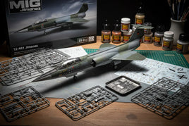 Scale model jet aircraft kit in progress with assembled plane, sprues, paints, and instructions on hobby workspace for MPM Hobbies.