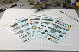 Lifelike Decals model airplane decal sheets on hobby workbench, with scale model planes and tools
