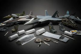 Scale model airplanes, helicopter, 3D printed parts, tools, and paint supplies on black surface