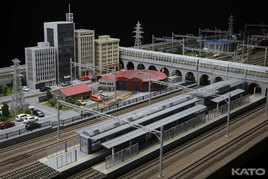 Model train station diorama with detailed buildings, cars, and tracks by MPM Hobbies