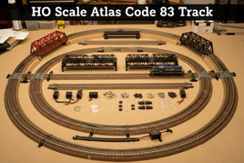 HO scale Atlas Code 83 model train track set with bridges, locomotive, and layout accessories on display.