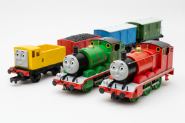 Three colorful toy trains with smiling faces and wagons on a white background, model trains MPM Hobbies