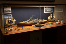Premium 1/200 scale model ship kits displayed on workbench featuring battleships and naval vessels with modeling tools