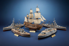 Detailed scale model ships 1/145-1/199 including sailing vessels and Civil War ironclads arranged on navy blue background with museum-quality lighting highlighting craftsmanship