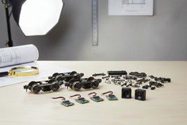 Model train parts, electronic circuit boards, and components on a workbench at MPM Hobbies.