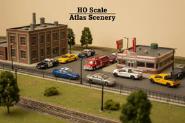 HO scale model scenery featuring buildings, diner, police cars, fire truck, and vehicles
