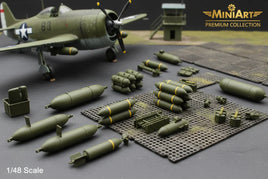 1/48 scale model airplane with detailed green military bombs, crates, and accessories on display mat