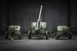 1/35 scale fixed weapons artillery collection featuring detailed German 88mm Flak gun, American 105mm howitzer, British 6-pounder anti-tank gun, and Bofors 40mm AA gun with realistic weathering and precision details