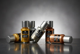 Vallejo Liquid Metal acrylic paint bottles in metallic colors on reflective surface, MPM Hobbies