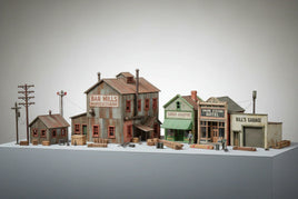 HO scale model buildings including Bar Mills Manufacturing, Corner Drugstore, Union Station Hotel, and Bill's Garage, displayed for MPM Hobbies.