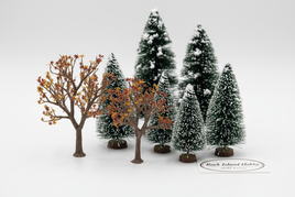 Rock Island deciduous and snow-covered pine fir trees in various sizes on white surface for model railroad scenery