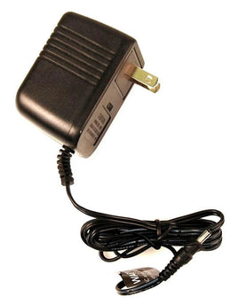Black electrical power adapter with US plug and coiled cable on white background