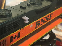 Model train engine with 'BNSF' branding and a Canadian flag on an orange background.