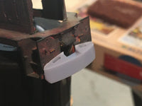 Close-up of a mechanical component with a white plastic part on a blurred background