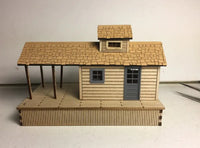 Model of a wooden cabin with a shingled roof on a plain background