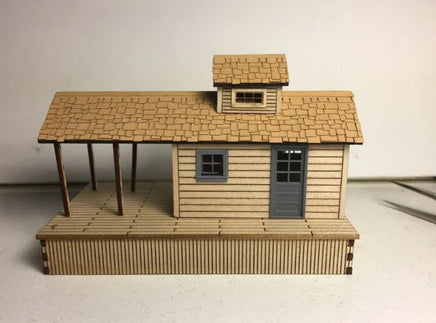 Model of a wooden cabin with a shingled roof on a plain background