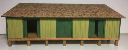Model of a green and brown building on a white background