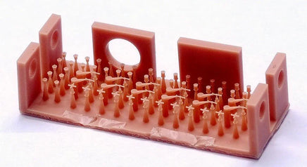 Pink plastic mold with small figurines on a white background