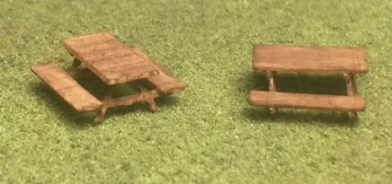 Two miniature picnic tables on a grassy background