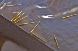 Gold-colored pins on a clear plastic surface