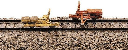 Model trains on a railway track with a close-up view of the tracks and models.