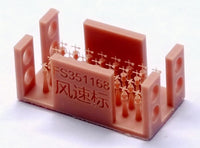Red plastic device with measurement markings and text on a white background