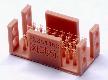 Red plastic device with measurement markings and text on a white background