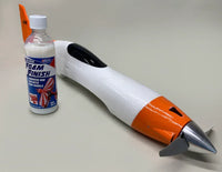 Foam finish bottle next to a model rocket on a light gray background