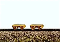 Small model train car on a track with a plain background