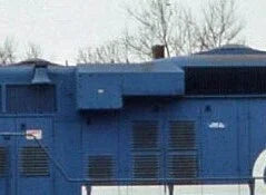 Blue industrial generator with visible branding on a clear day