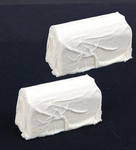 Two blocks of white cream on a black background