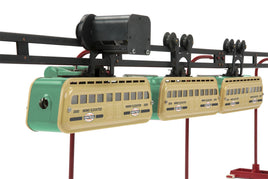 Model train set with three cars on a track against a white background