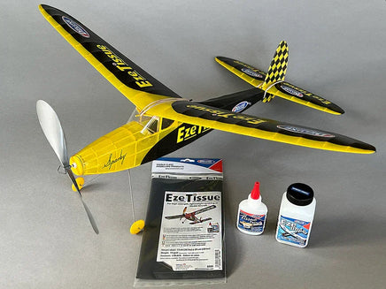 Model airplane with propeller, EzeTissue packaging, and bottles on a gray background