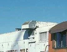 White building with a small structure on top against a clear blue sky