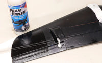 Black foam finish product on a white surface with a bottle of Foam Finish cleaner.