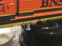 Close-up of a model train car with 'BNSF' branding on a black surface.