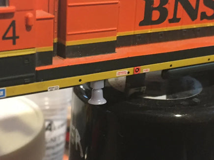 Close-up of a model train car with 'BNSF' branding on a black surface.