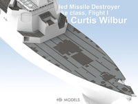 Model of a guided missile destroyer with text indicating 'Curtis Wilbur' on a light blue background.