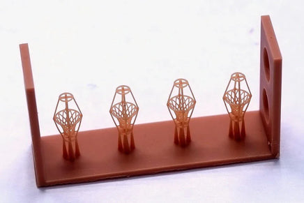 Decorative item with four geometrically shaped objects on a brown base against a white background