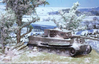 Tank in a snowy landscape with trees and mountains in the background