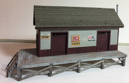 Model of a small building with a roof and platform on a plain background