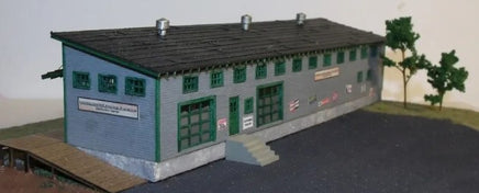 Model of a building with green doors and windows on a plain background