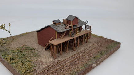 Model of a rustic wooden cabin with a deck on a white background
